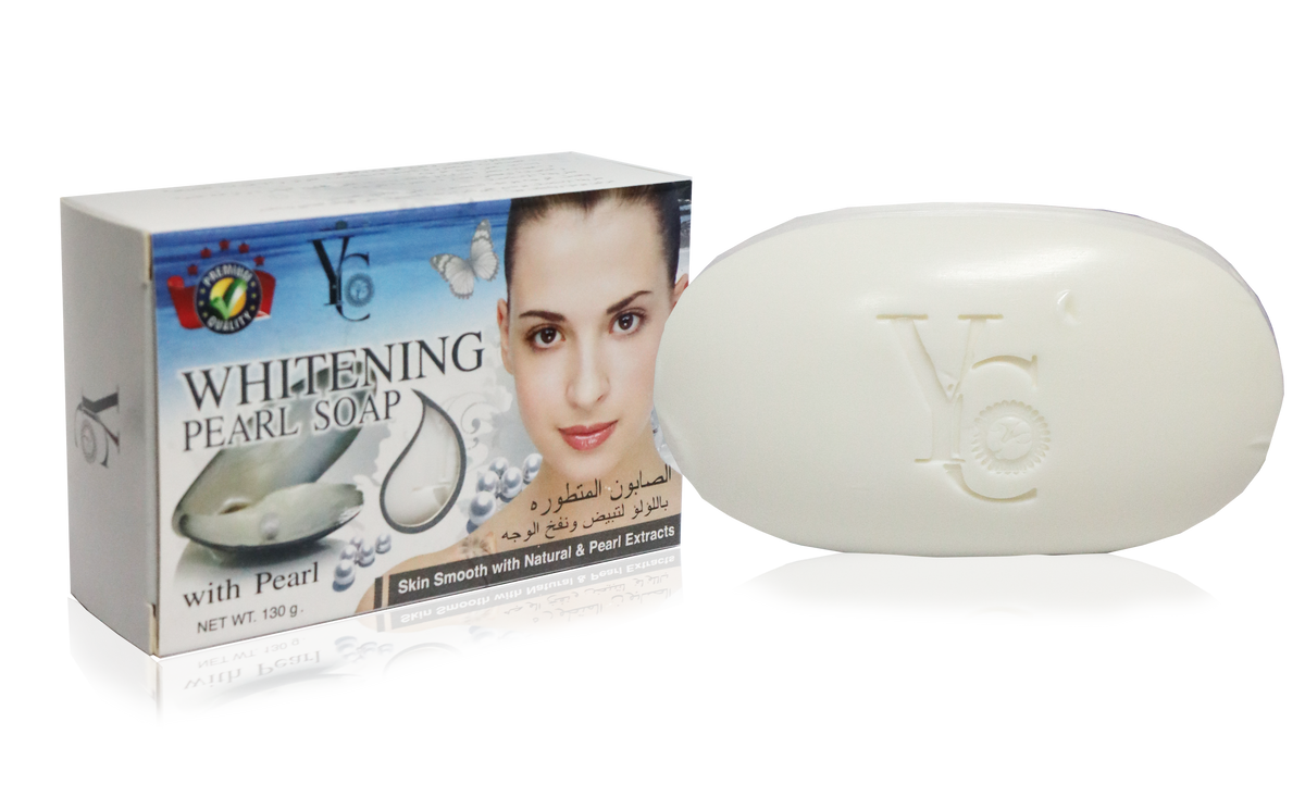 A bar of Y6 Whitening Pearl Soap shown next to its retail box on a reflective white background. The soap bar is off-white with an embossed Y6 logo, and the box features a model's face, pearl imagery, and text indicating skin whitening and smoothing benefits.
