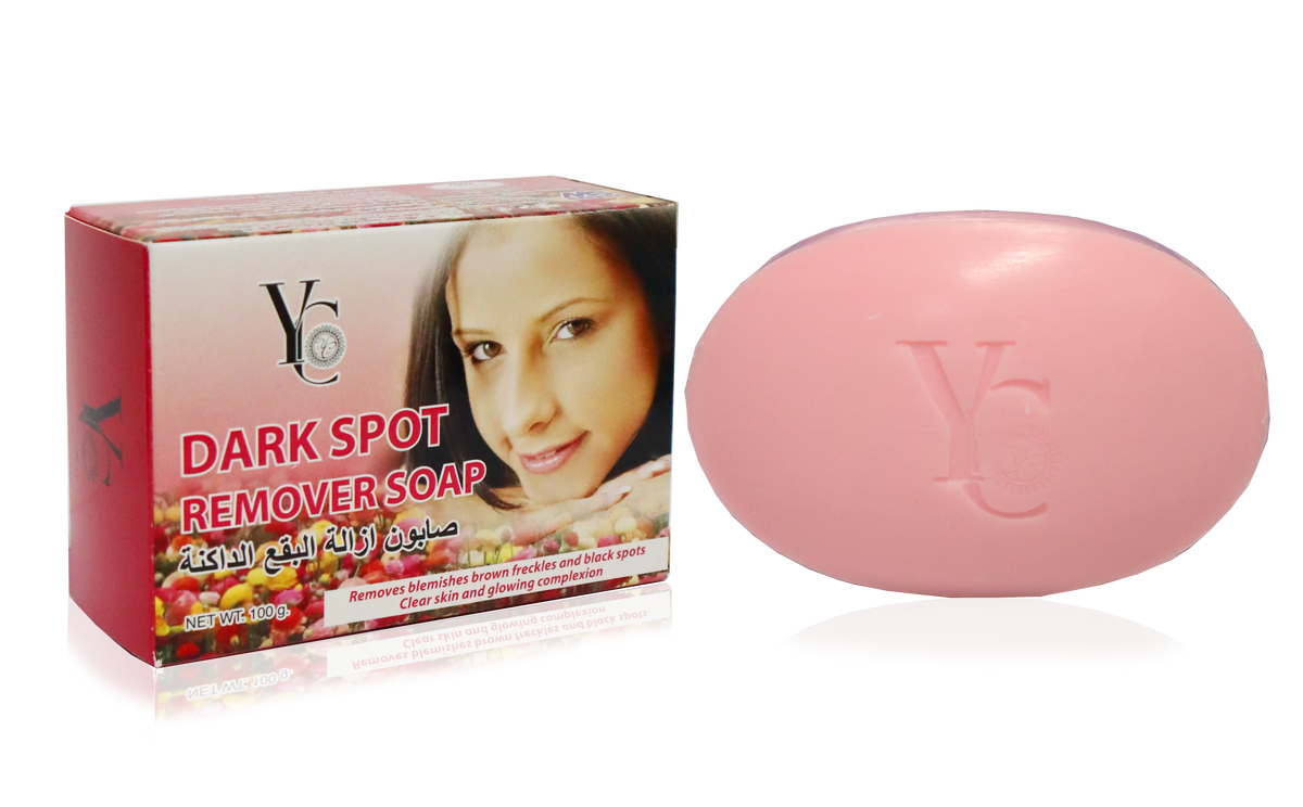 A pink oval bar of soap next to its red and white retail box labeled 'DARK SPOT REMOVER SOAP' with a woman's face printed on the packaging, shown on a white background.